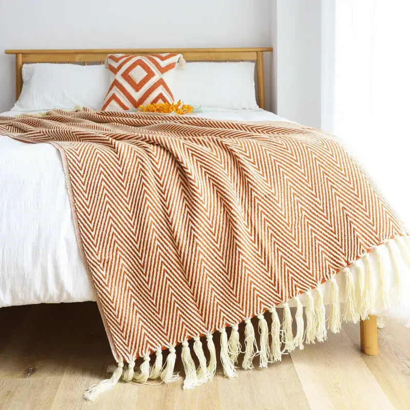 A cozy terracotta and cream herringbone patterned knitted blanket with soft fringed tassels for stylish decorbites geometric decor