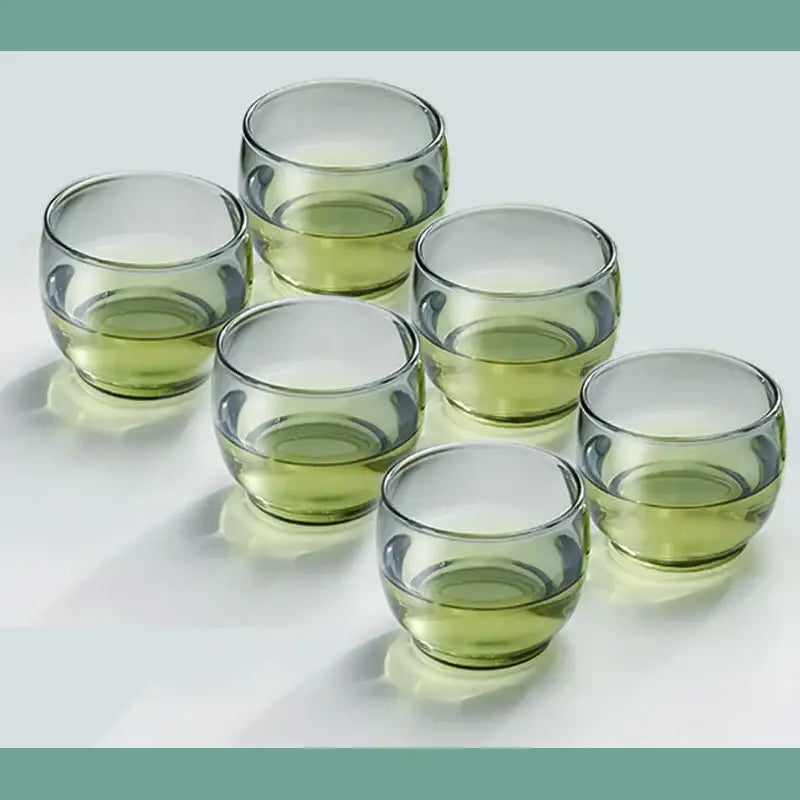 Set of six translucent olive green decorbites glass tea cups with rounded bowls and smooth rims for kung fu tea