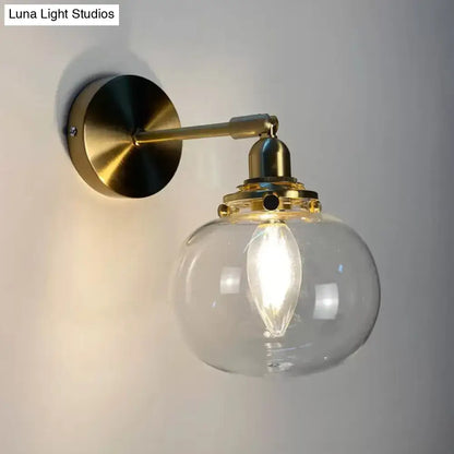 Brass finished wall lamp with clear glass globe and exposed filament bulb for bedroom wall lamp use