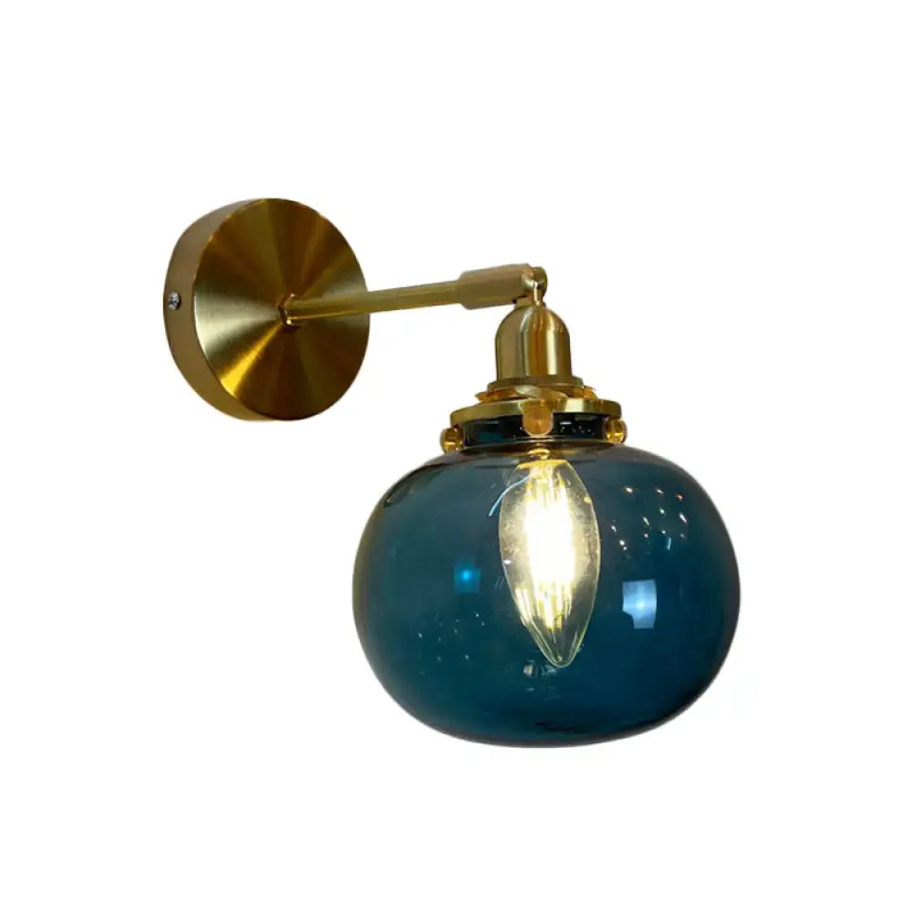 Deep blue glass globe wall lamp with brass hardware and visible filament bulb for bedroom wall lamp use