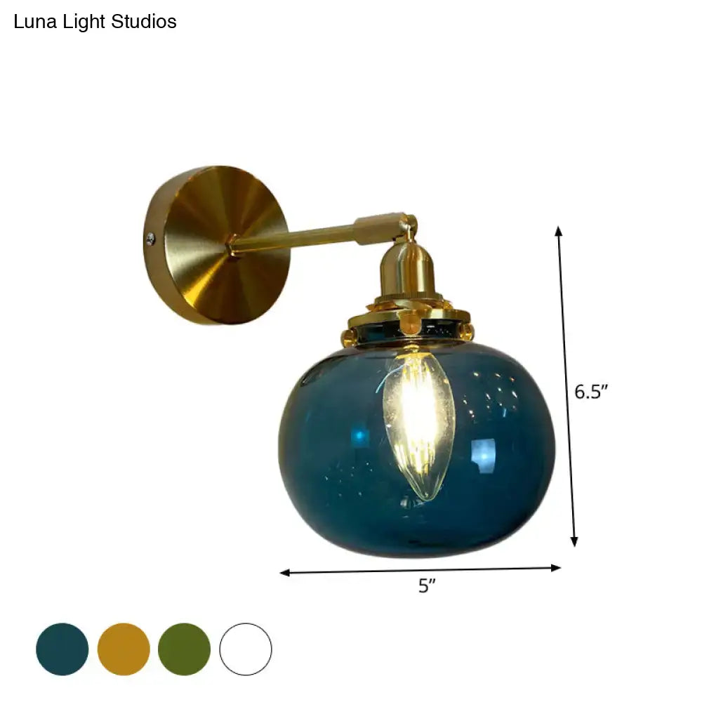 Deep teal glass globe bedroom wall lamp with brass hardware and vintage filament bulb for elegant bedroom wall lighting