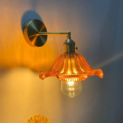 Orange and gold fluted glass wall lamp with brass arm designed as a bedroom wall lamp for bedroom wall decor