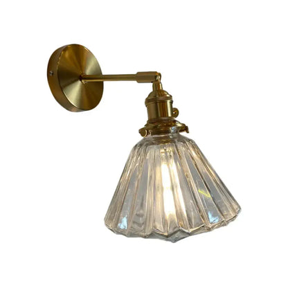 A vintage-style brass wall lamp with a clear faceted glass shade for bedroom wall use