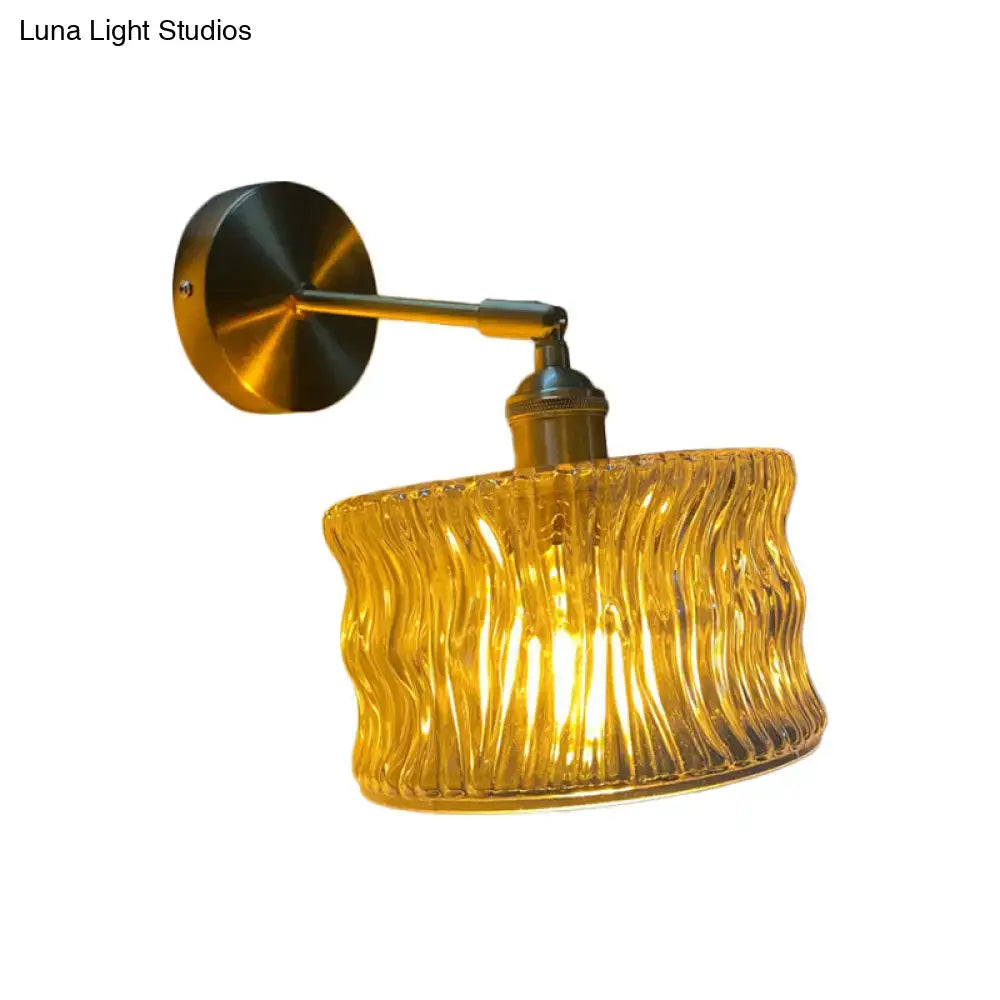 A warm amber fluted glass wall lamp with ribbed texture and brass arm for bedroom wall lamp use
