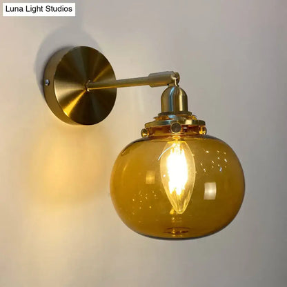 Orange and gold fluted glass wall lamp with warm amber globe and brass arm for elegant bedroom wall lighting