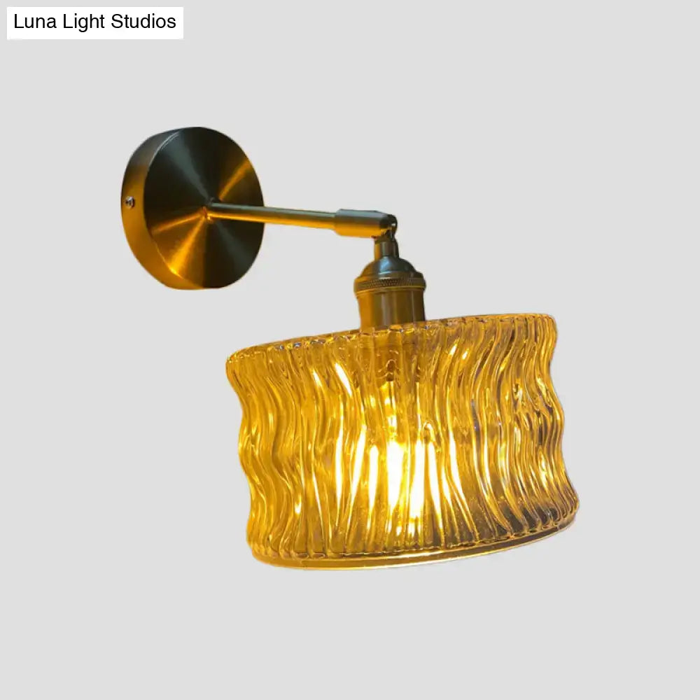 A warm amber and gold fluted glass wall lamp with brass hardware for elegant bedroom wall lighting