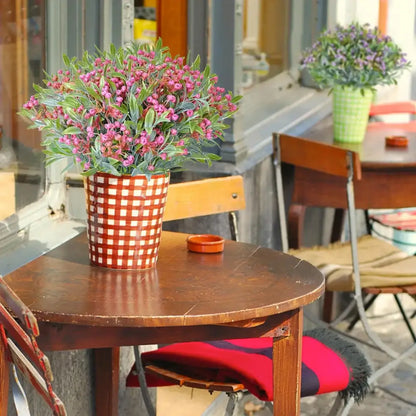 A vibrant pink flowering babysbreath lover fruit artificial plant in a red and white checkered ceramic pot for decor