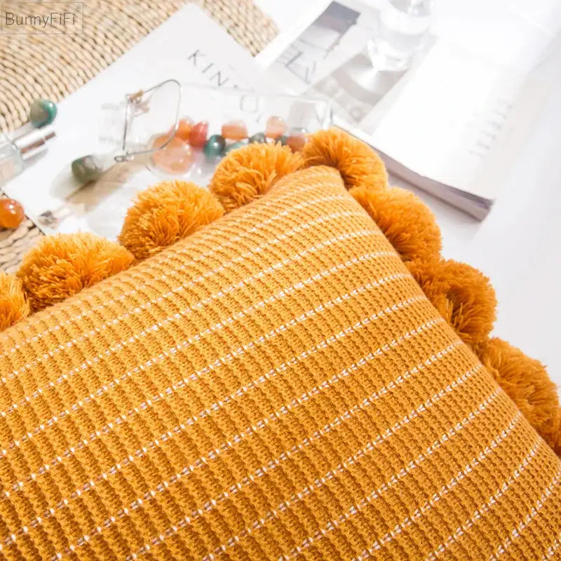 Orange textured ball cushion cover with white stripes and fluffy pom-poms for living room decor