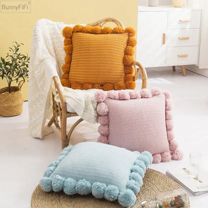 Orange textured ball cushion cover with fluffy pom-pom trim for stylish living room decor and comfort