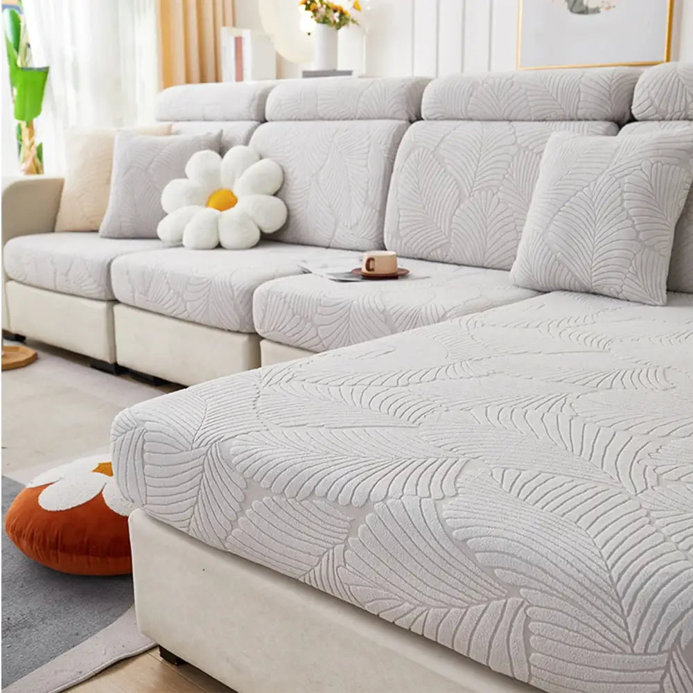 Light gray jacquard stretch sofa cover with subtle embossed leaf pattern for orange and white living room protector