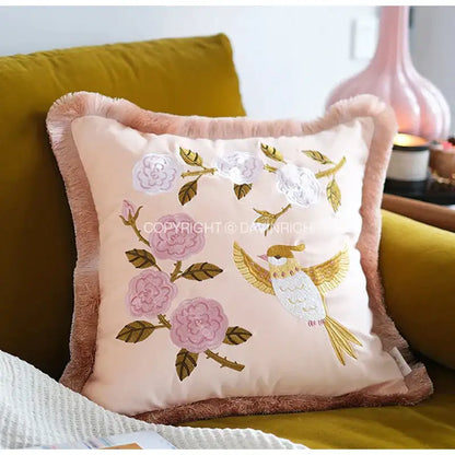 A soft peach pillow cover with delicate pink and white floral bamboo embroidered fringed details for bedroom decorbites