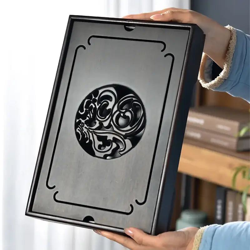 Ornate black bamboo tea tray with circular cutout and decorative curved lines for dining room drainage use