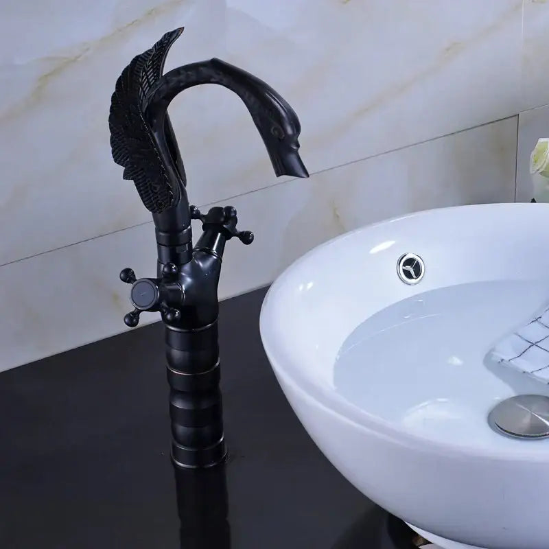 Ornate black bronze swan basin faucet with detailed feathered wings and dual cross handles for bathroom use by decorbites