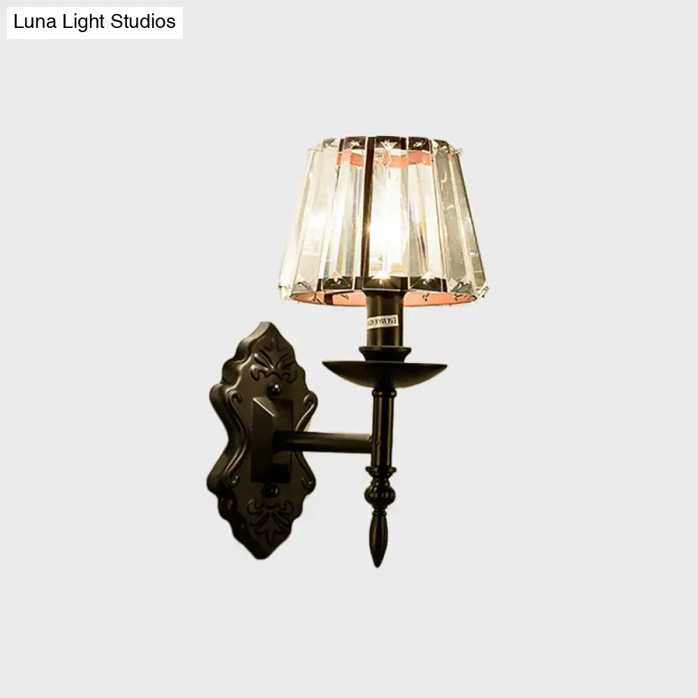 Antique bronze finish wall light with tiered crystal prisms and ornate design for bedroom sconce lighting