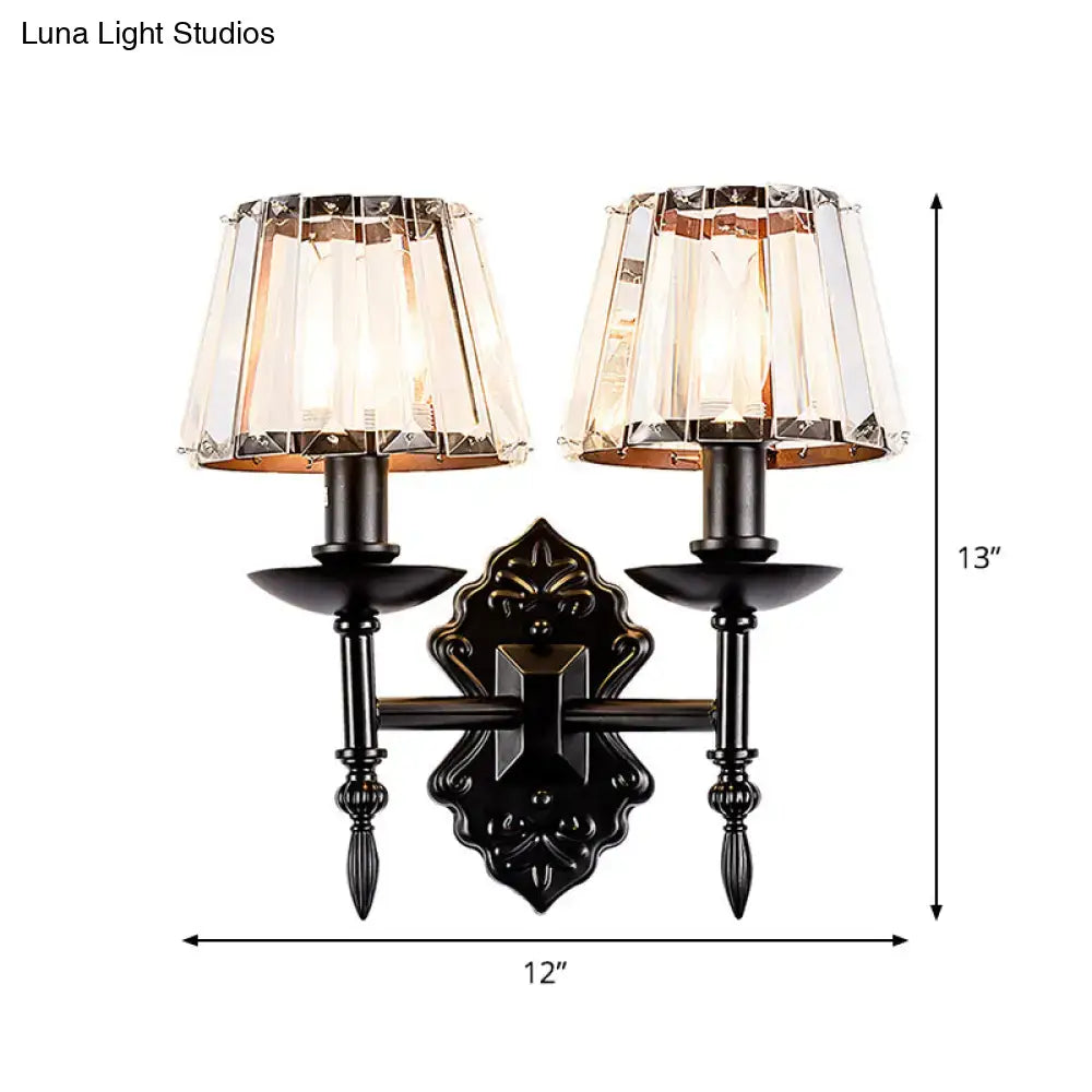 Ornate black finish wall light with two crystal prisms lampshades designed as a bedroom sconce