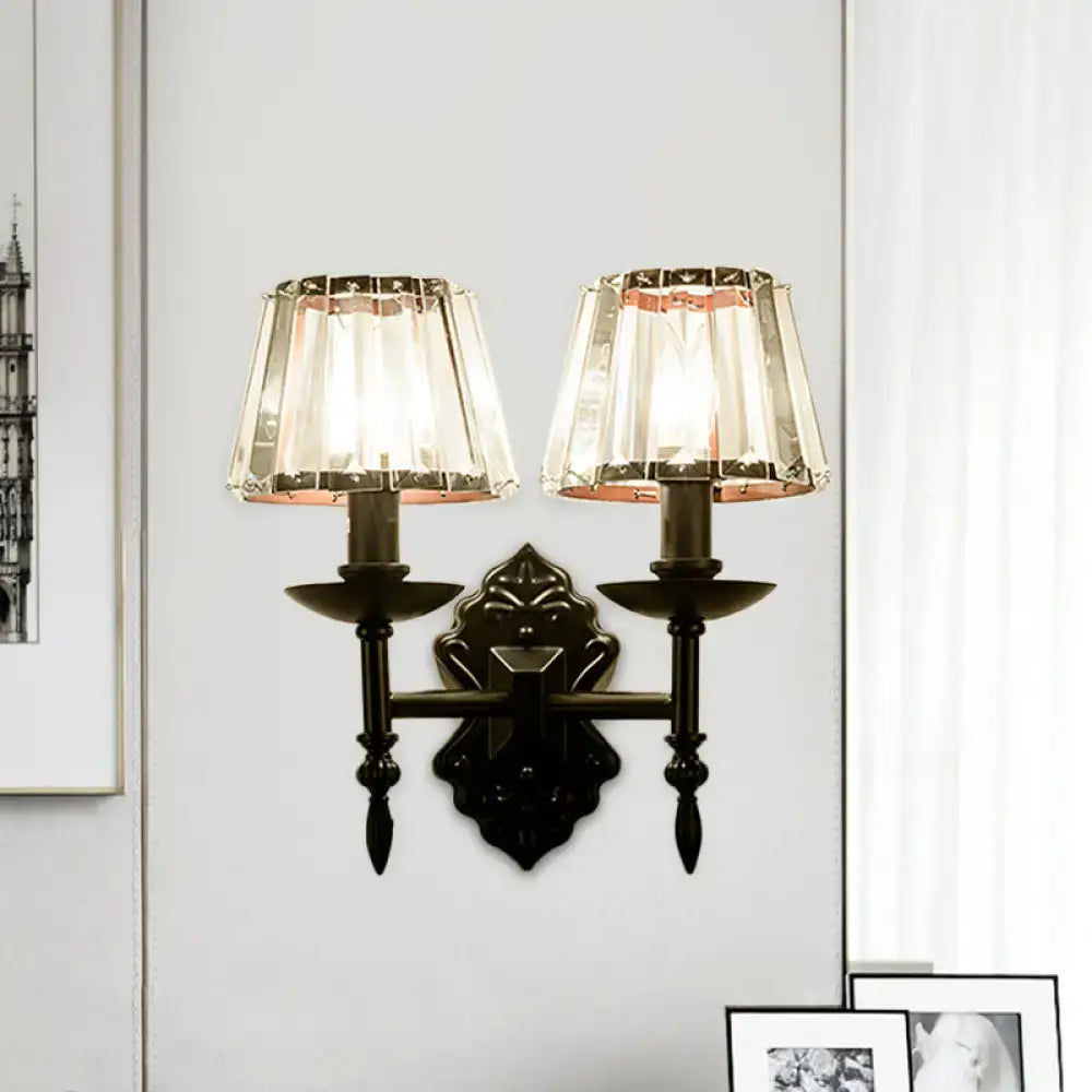 Black wrought iron wall light with crystal prisms and black finish featuring two ornate bedroom sconce shades