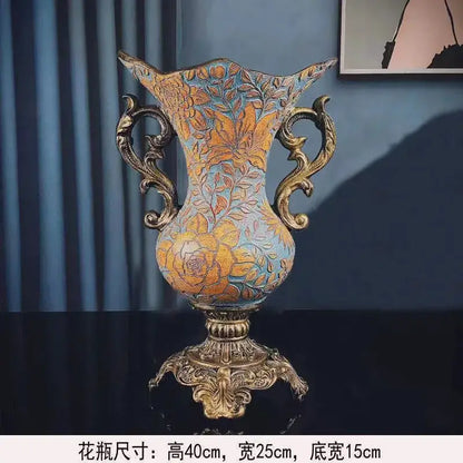 Antique-style resin vase dried with ornate gold handles and floral patterns in gold on muted blue for living room decor