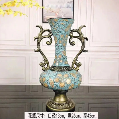 Ornate turquoise and gold resin vase dried with intricate floral patterns and curved handles for living room decor