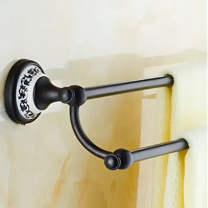 Ornate black wrought iron double towel rack with white and black floral mounting plate in bathroom accessories set