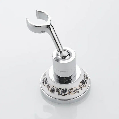 Chrome-finished bathroom towel rack with ornate white ceramic base and black floral patterns for handheld shower mount bracket