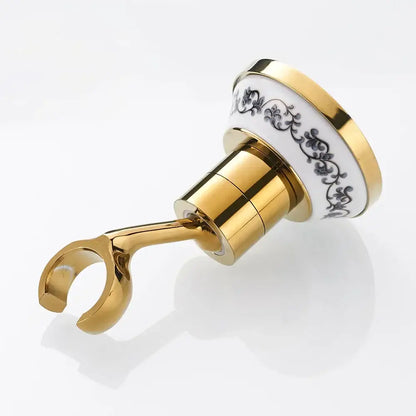 Gold-toned bathroom towel rack with white ceramic top black floral detailing and polished brass shower mount bracket