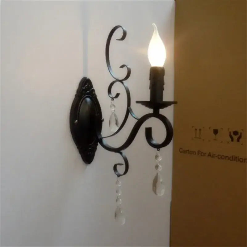 Ornate black wrought iron wall lamp with crystal teardrop pendants and candle-style bulb for living room decorbites black wrought