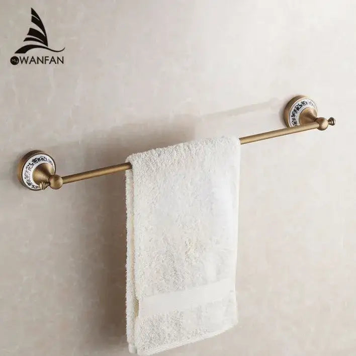 Antique brass towel rack with blue floral ceramic end caps part of ornate brass and white ceramic bath hardware set