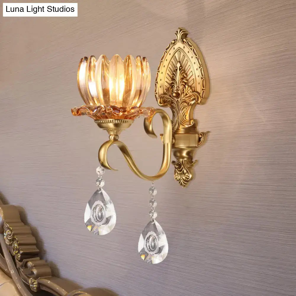 Ornate brass lotus wall sconce with gold tone lotus glass shade and dangling crystals designed for e14 bulb use