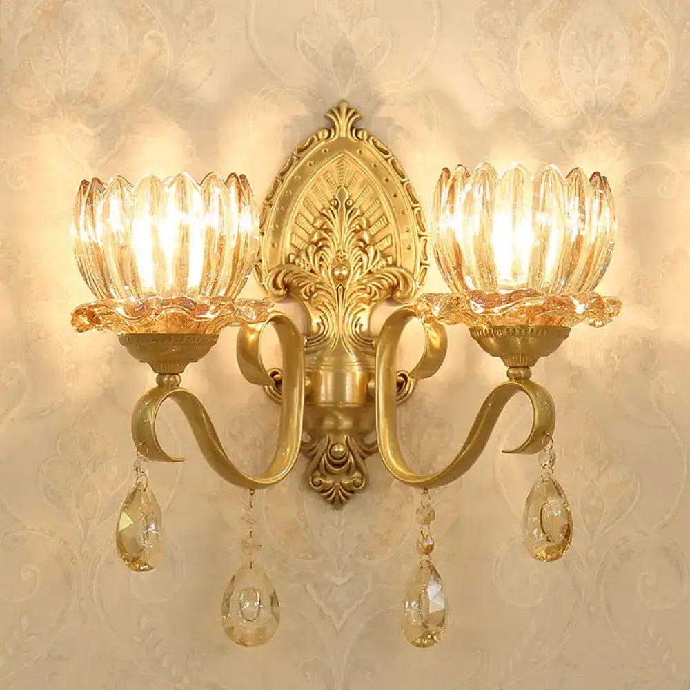 Ornate gold-toned brass wall sconce with two crystal lotus shades and dangling teardrop crystals compatible with e14 bulb