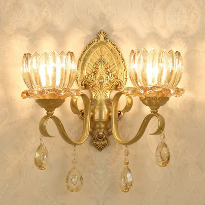 Ornate gold-toned brass wall sconce with two crystal lotus shades and dangling teardrop crystals compatible with e14 bulb