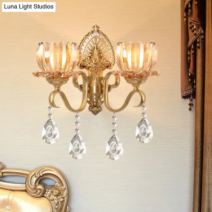 Ornate brass lotus wall sconce with gold-toned finish, amber glass, fluted crystal shades, and e14 bulb compatibility