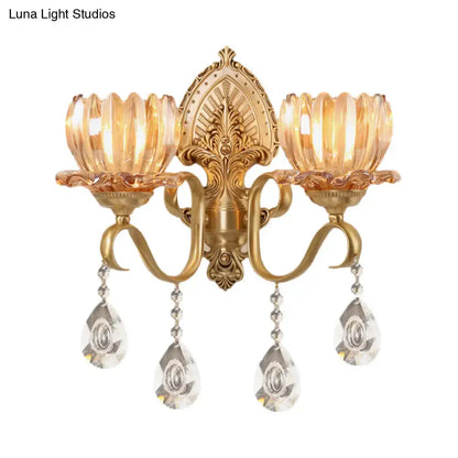 Ornate brass lotus wall sconce with gold-toned finish amber glass shades and dangling crystal pendants for e14 bulb use