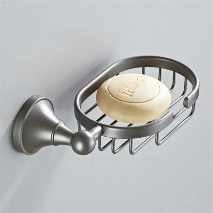 Ornate brushed nickel gray bathroom accessories set featuring a silver soap dish with wire mesh holding zenoys soap