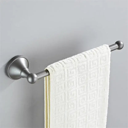 A sleek brushed nickel towel rack with a white textured towel in an ornate gray bathroom accessories set decorbites gray bathroom