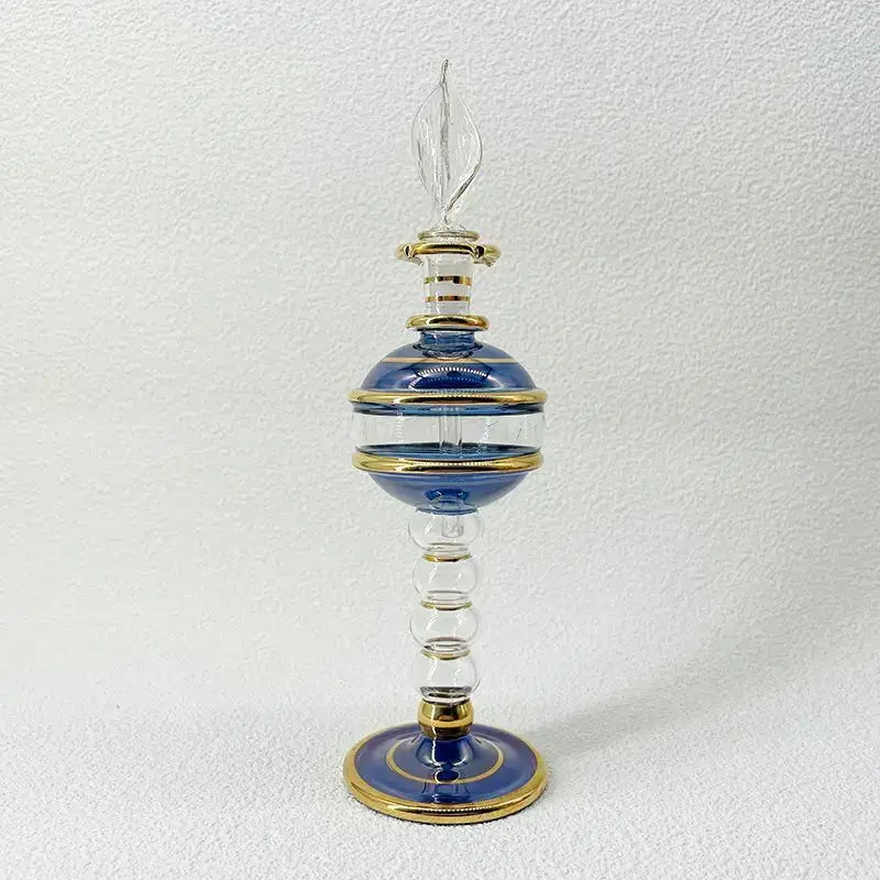 Elegant blue and gold glass bottle with clear flame-shaped stopper as ornate glass bottle jewelry ornaments for decor