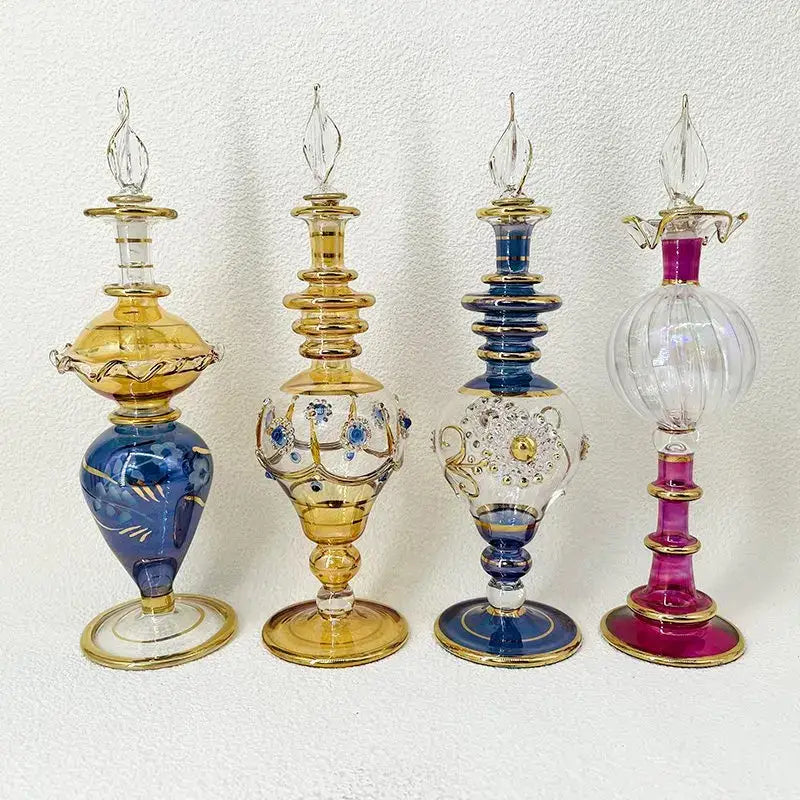 Four ornate glass bottle jewelry ornaments in vibrant blue amber and magenta with gold accents for bedroom decor