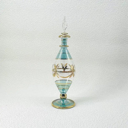 A tall elegant light blue glass bottle with gold leaf detailing used as glass bottle jewelry ornaments