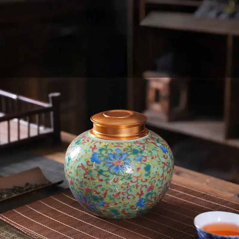 Ornate floral ceramic storage jar with gold-toned lid in blue red and green on mint-green for tea and coffee storage