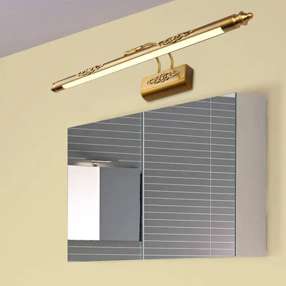 Ornate gold brass wall vanity light with warm white glow and intricate floral detailing on rectangular bracket