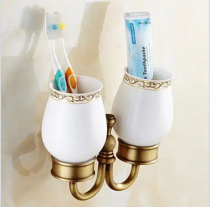White ceramic toothbrush holder with gold carved detailing and brass base from decorbites copper carved bathroom set