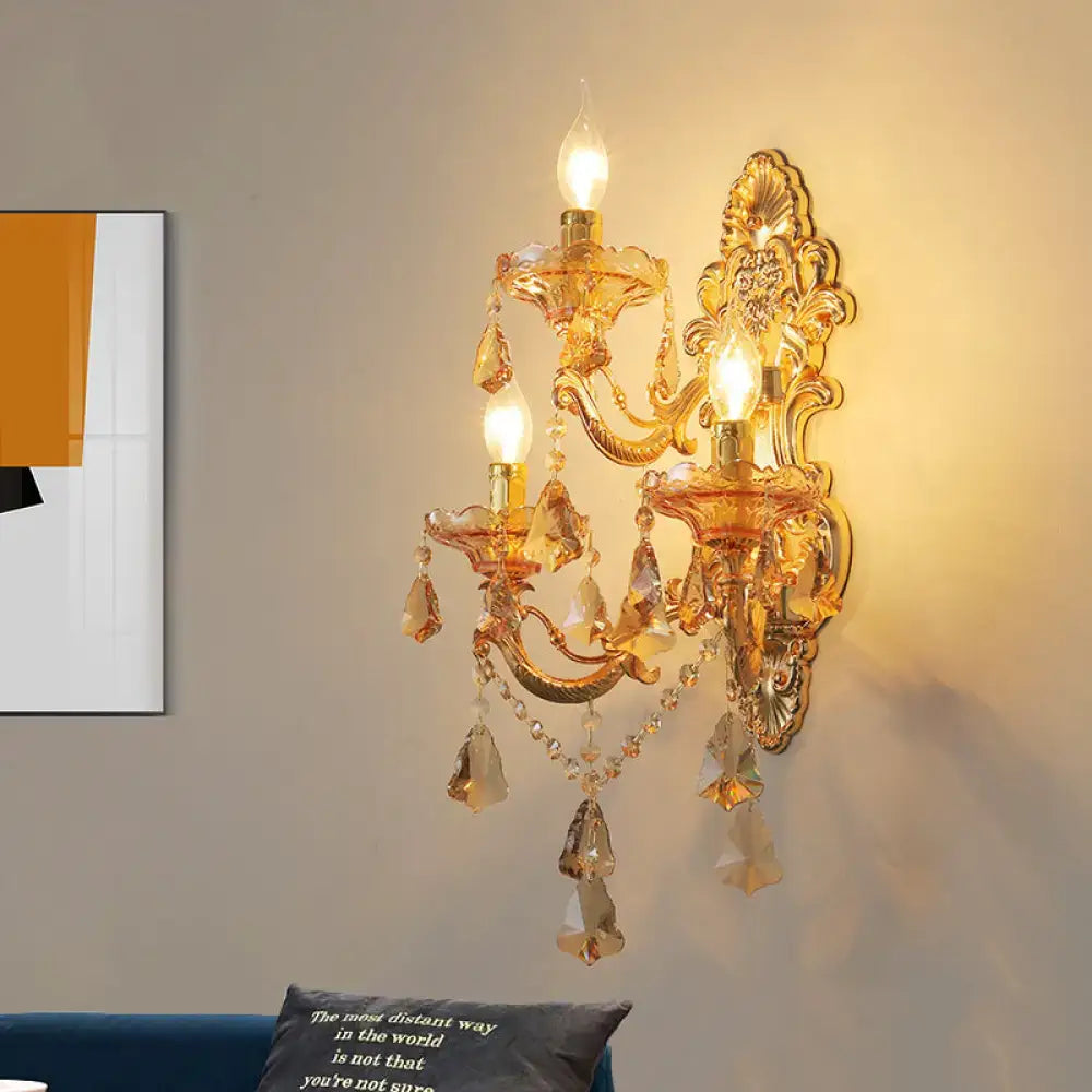 Ornate gold metal fixture living room sconce with three lit candle-style bulbs crystal droplets and dangling beads inch fixture