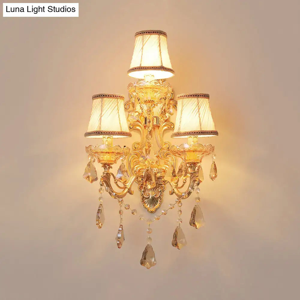 Ornate gold metal fixture living room sconce with three cream lampshades and dangling crystal droplets inch fixture