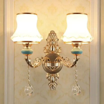 Ornate gold crystal wall sconce with two frosted shades and dangling teardrop pendants for bedroom decorbites wall sconce