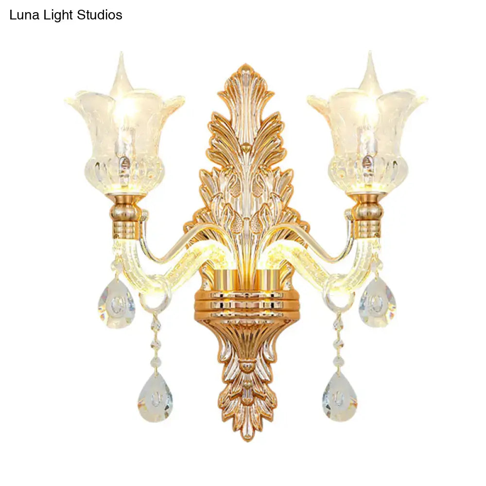 Ornate gold floral wall lamp featuring clear crystal glass teardrop pendants and frosted tulip shades for bedroom use