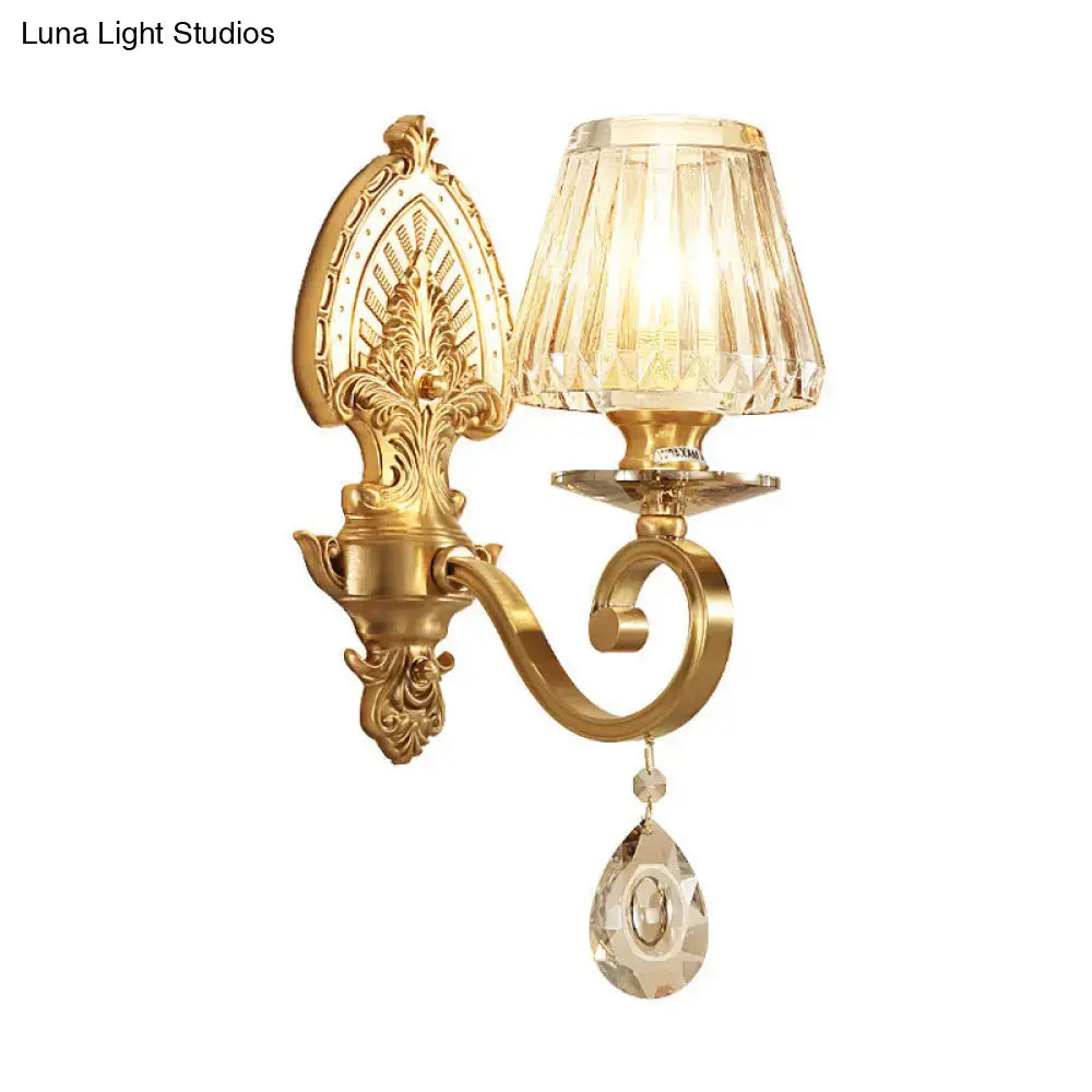 Ornate gold wall sconce contemporary with prismatic faceted crystal shade and teardrop crystal pendant for bedroom lighting