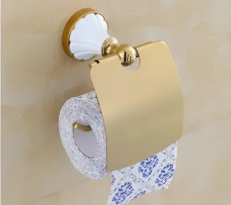 Gold-colored ceramic toilet paper holder with fluted design and matching bracket in decorbites bathroom accessories set