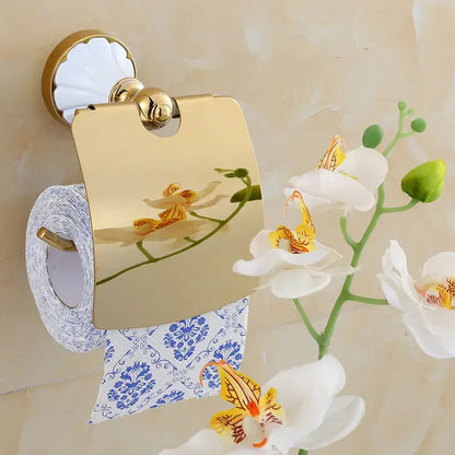 Ornate gold finished toilet paper holder with mirrored surface reflecting orchids in decorbites bathroom accessories set