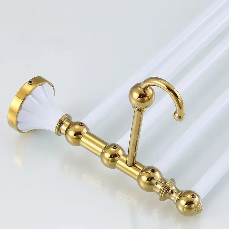 Gold-toned metal curtain rod holder with white ceramic finial and decorative spheres in decorbites bathroom accessories set