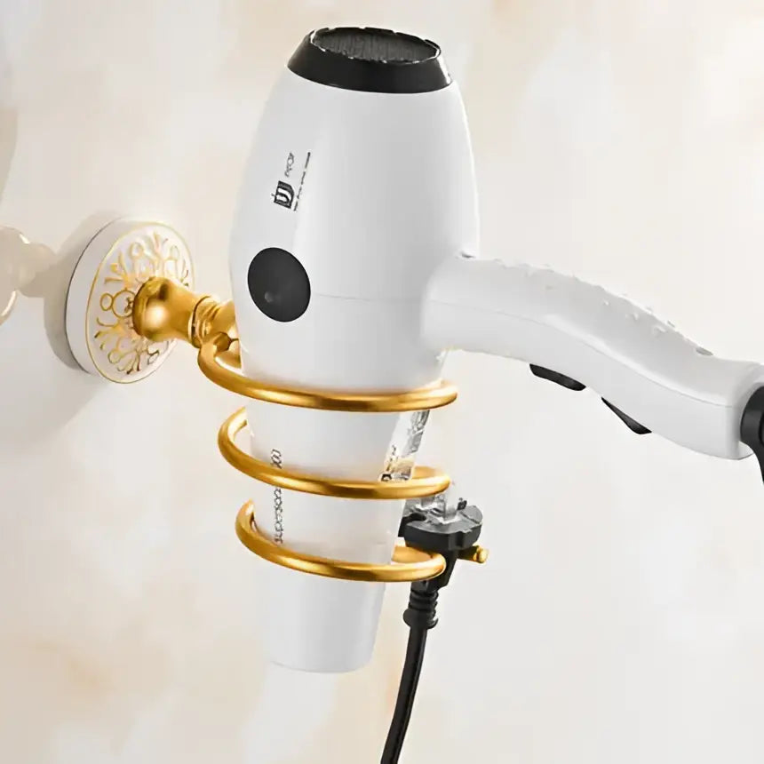 White hair dryer with black accents in a gold wall-mounted holder from decorbites bathroom accessories set