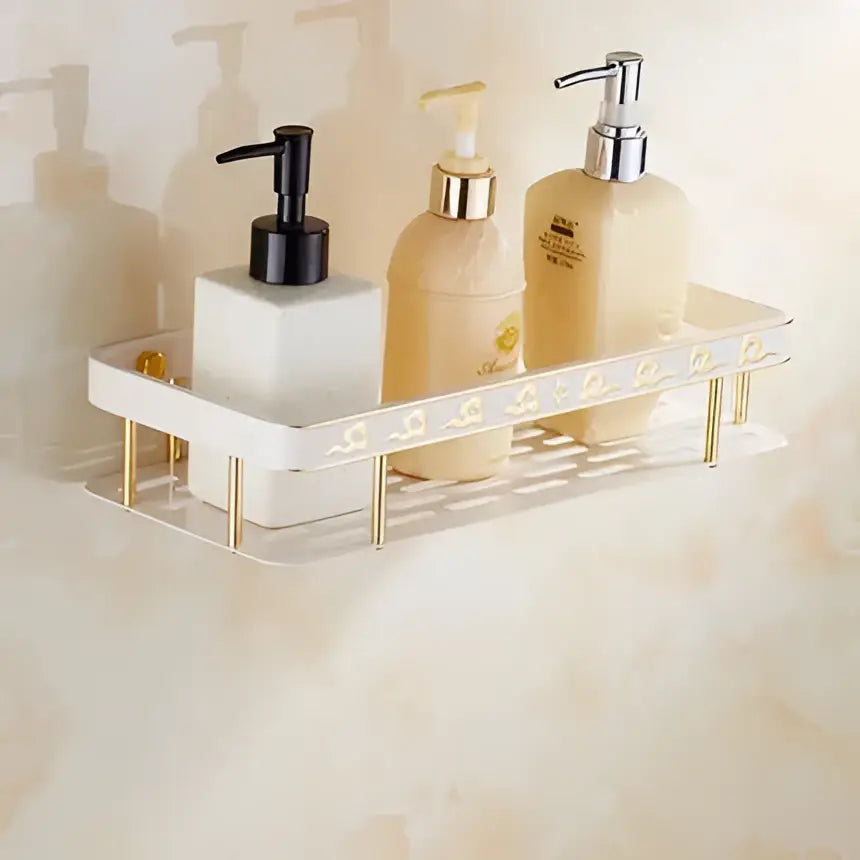 Ornate gold and white floral decorbites bathroom accessories set with gold-toned metal shelf holding soap dispensers and lotion bottles